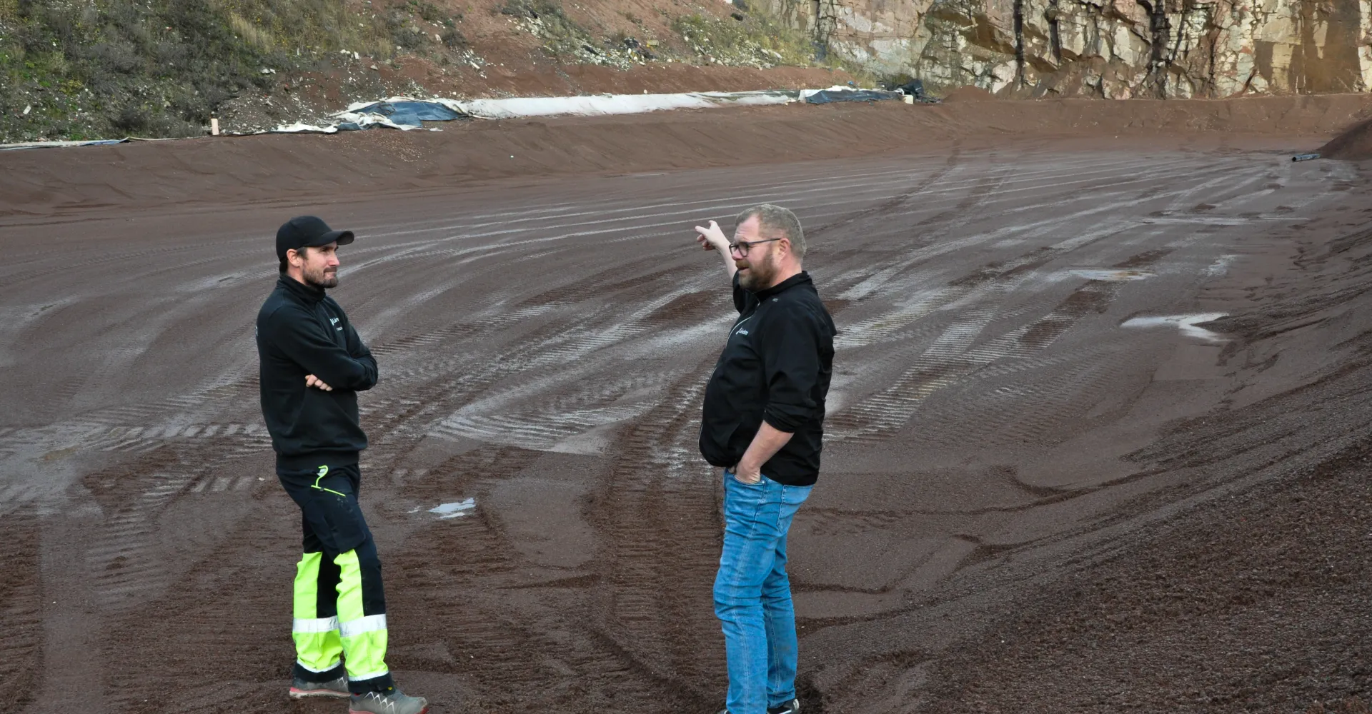 Anleggsleder og kollega viser frem området som er klargjort for tilkjøring av de spesielle massene fra Slettebakken