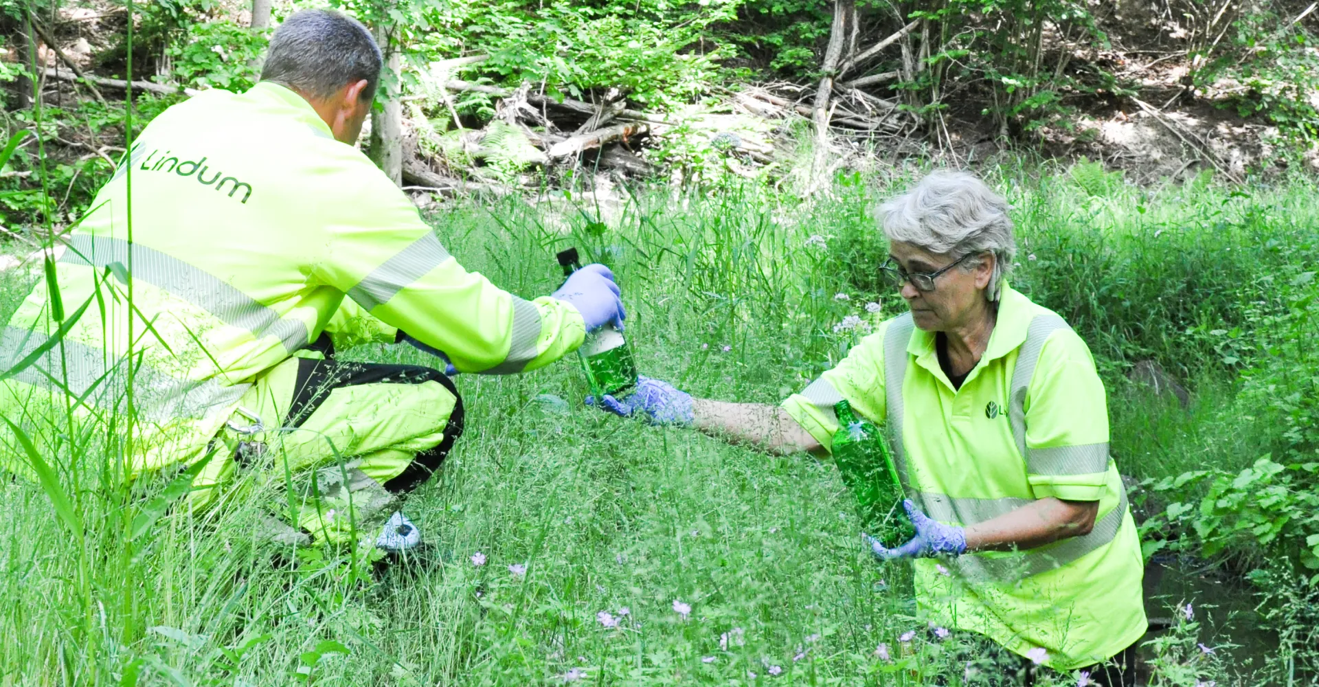 To Lindum-medarbeidere tar tuinemessige vannprøver av bekker og kummer