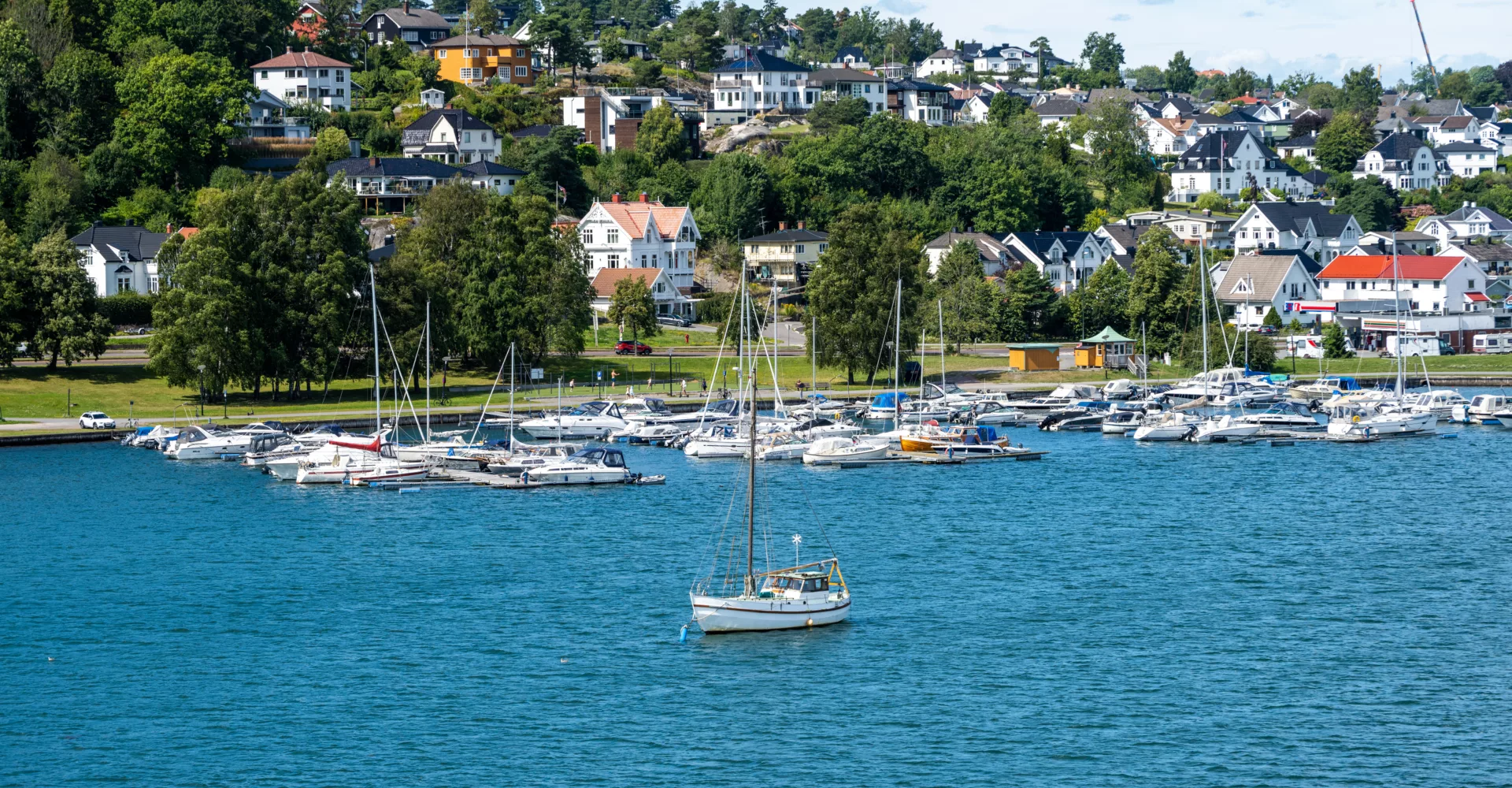 Båthavn sørlandsby med boliger i bakgrunn