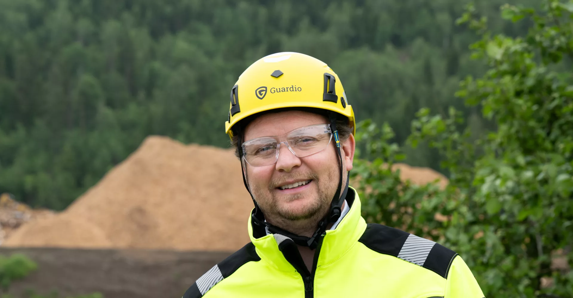 Mann med hjelm og vernebriller foran Lindums anlegg