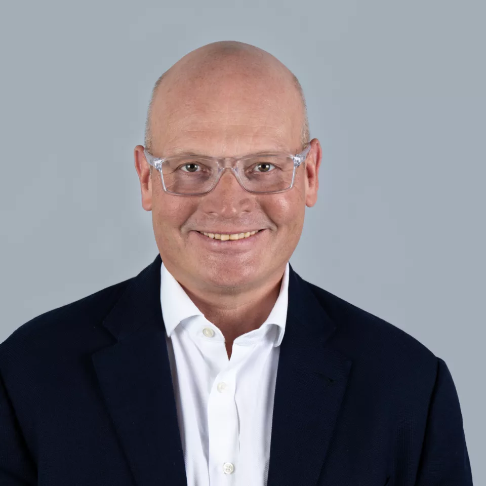Portrettbilde av Nils Aas med grå bakgrunn